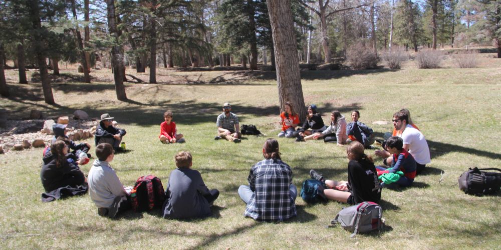 students sitting outside in a circle