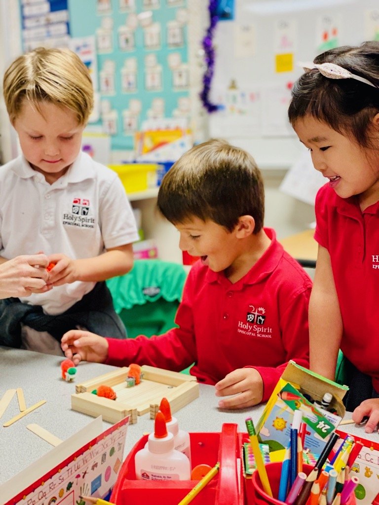 Three primary students playing with blocks